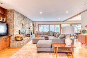 sala de estar con sofá y pared de piedra en Retreat on the Salmon River en Welches