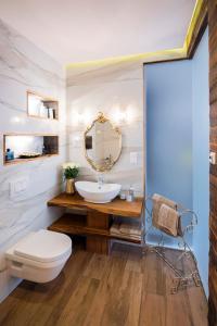 a bathroom with a sink and a toilet and a mirror at Apartament Angel in Gdynia