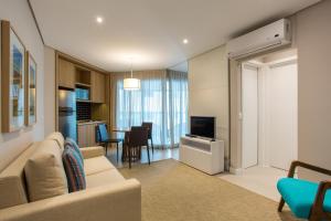 a living room with a couch and a dining room at 2 quartos- Estanconfor Vista Mar AC garagem sacada in Santos