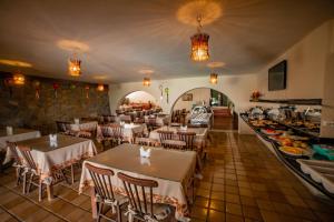 un ristorante con tavoli e sedie e un buffet di Hotel Três Palmeiras a Gravatá