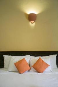 een bed met oranje en witte kussens en een licht bij Hotel Casa del Consulado in Granada