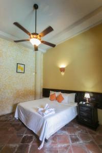 een slaapkamer met een bed en een plafondventilator bij Hotel Casa del Consulado in Granada