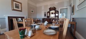een eetkamer met een houten tafel en stoelen bij Brooke House in Shanklin
