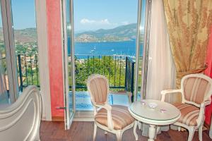 Zimmer mit einem Tisch und Stühlen sowie einem großen Fenster in der Unterkunft Swan Lake Hotel - Adult Only in Selimiye