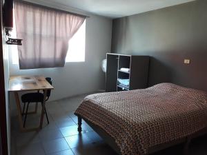 a bedroom with a bed and a desk and a window at Posada Loreto Xalapa in Xalapa