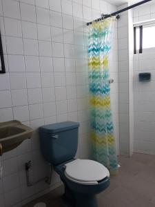 een badkamer met een blauw toilet en een douchegordijn bij Posada Loreto Xalapa in Xalapa