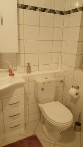 a white bathroom with a toilet and a sink at Apart in Bremerhaven