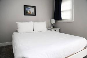 uma cama branca num quarto com uma janela em NEW 2BR Apartment near Lake Winnipesaukee em Wolfeboro