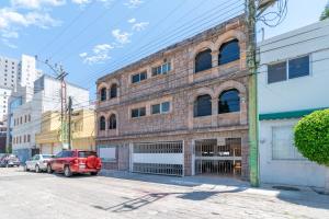 un'auto rossa parcheggiata di fronte a un edificio di mattoni di Espaciosa Suite Zona Centro Col El Prado S7 a Casa Blanca La Corregidora