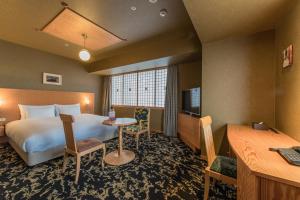 大分市にあるＪＲ九州ホテルブラッサム大分のベッドとデスクが備わるホテルルームです。