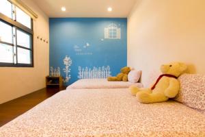 小琉球的住宿－月掬生態旅遊民宿 ，两个泰迪熊坐在一个房间里的床边
