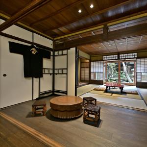a room with a table and a t shirt hanging on a wall at Nishijin Fujita in Kyoto