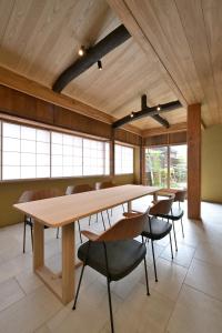 a large room with tables and chairs and windows at Nishijin Fujita in Kyoto