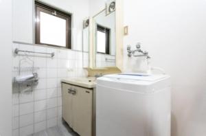 a bathroom with a sink and a toilet and a mirror at Secret House - 2 min to FuSe station - in Osaka