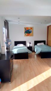 a bedroom with two beds and a table and a desk at Simon's place in Ponta Delgada