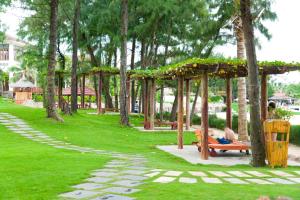 a person sitting on a bench in a park at Ca Ty Muine Beach Resort & Spa in Mui Ne