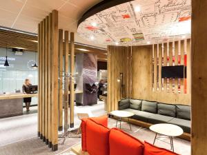 a lobby with a couch and tables and a tv at Ibis Moscow Centre Bakhrushina in Moscow