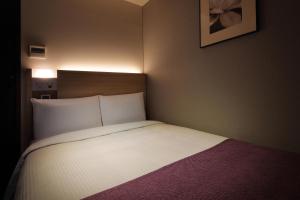 Postel nebo postele na pokoji v ubytování Keio Presso Inn Tokyo Kudanshita