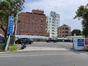 un aparcamiento con coches estacionados frente a los edificios en Kaishen Hotel en Taitung