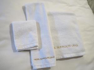 dos toallas blancas sentadas encima de una cama en Hotel Sunroute Stellar Ueno, en Tokio
