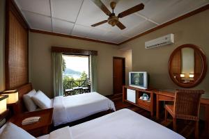 a hotel room with two beds and a mirror at Redang Island Resort in Redang Island