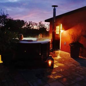 two people in a hot tub in a backyard at night at Villa Gina Österlen in Sankt Olof