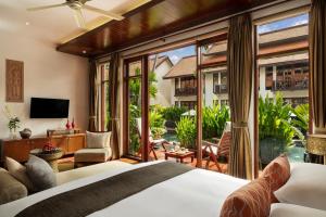 sypialnia z łóżkiem i dużym oknem w obiekcie Anantara Angkor Resort w Siem Reap