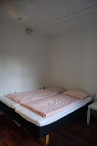 Bett in einem Zimmer mit einer weißen Wand in der Unterkunft Charming Red Courtyard Apartment in Kopenhagen