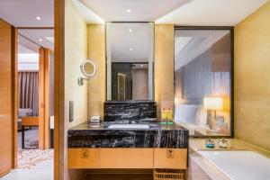 a bathroom with a sink and a tub and a mirror at Holiday Inn Chengdu Oriental Plaza, an IHG Hotel in Chengdu