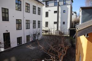 an empty courtyard in front of two white buildings at Rooms in quiet Yellow Courtyard Apartment in Copenhagen