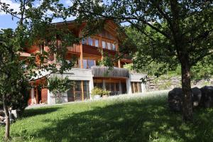 a house on a hill with a green lawn at Ferienwohnung Leuweli in Hasliberg