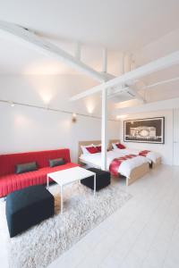 a bedroom with two beds and a red couch at ゲストスイート福菊 in Kyoto