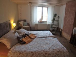 a bedroom with a bed and a window and a chair at BnB Lafleur in Montfaucon