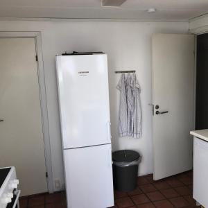 a white refrigerator in a kitchen next to a door at Rooms in quiet Yellow Courtyard Apartment in Copenhagen