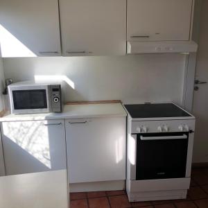 a kitchen with a stove and a microwave at Rooms in quiet Yellow Courtyard Apartment in Copenhagen