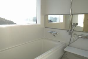 a white bathroom with a tub and a window at MY LODGE Naoshima in Naoshima