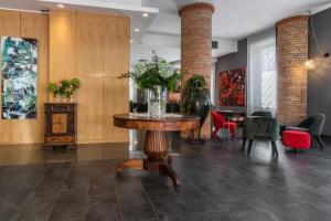 een lobby met een tafel met een vaas met bloemen erop bij Hotel Residence Ristorante Ramandolo in Udine