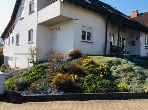 a house with a flower garden in front of it at Fernblick in Zweibrücken