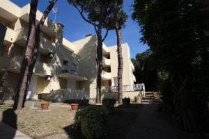 um edifício com árvores em frente em Residence Verdena appartamento 02 em Rosolina Mare