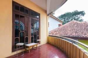 uma varanda com dois bancos e uma porta numa casa em SPOT ON 2689 Safira Family Residence Syariah em Bukit Lawang