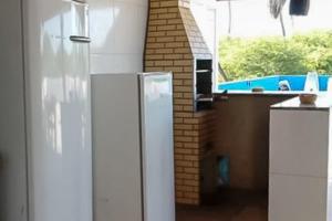 a white refrigerator in a kitchen with a window at Recanto Maristela in Grossos