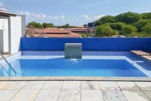 a blue swimming pool with a blue wall at Recanto Maristela in Grossos