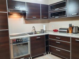a kitchen with wooden cabinets and stainless steel appliances at Apartament w Porcie - 365PAM in Kołobrzeg