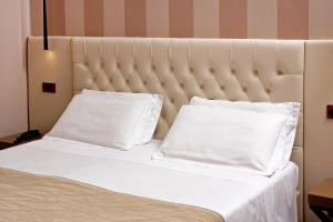 a bed with two white pillows on it at Hotel Arcangelo in Rome
