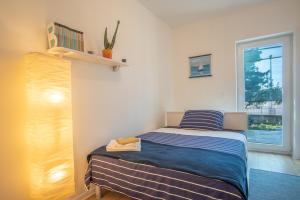 a small bedroom with a bed and a window at Apartman Soto in Pirovac