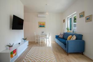 a living room with a blue couch and a table at Apartman Soto in Pirovac