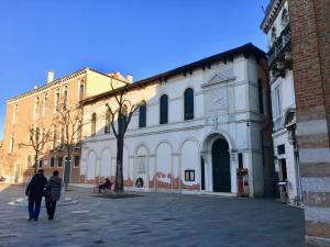 2 personnes marchant devant un bâtiment blanc dans l'établissement Museums District, à Venise