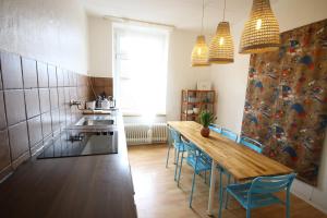 a kitchen with a wooden table and blue chairs at Moderne Studio Apartments und 120qm Wohnungen in Oberhausen, ideal für Geschäftsreisende und Monteure in Oberhausen