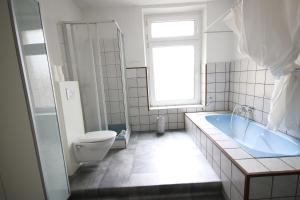 a bathroom with a tub and a toilet and a sink at Moderne Studio Apartments und 120qm Wohnungen in Oberhausen, ideal für Geschäftsreisende und Monteure in Oberhausen +57 photos
