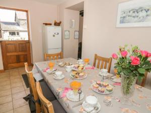 a dining room table with dishes and flowers on it at Ysgubor Newydd in Conwy